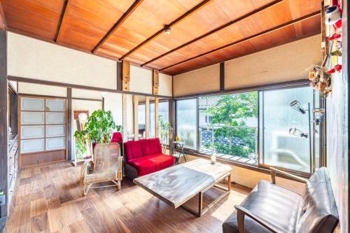 a living room with a red couch and a table at まろや四季 in Ōzu