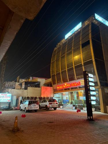 a building with cars parked in a parking lot at night at Hotel Northwind Mohali in Mohali