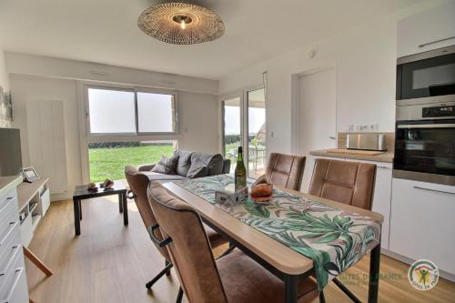 une cuisine et une salle à manger avec une table et des chaises dans l'établissement La plage, à Trébeurden
