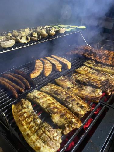 a bunch of sausages and other foods on a grill at Natural e Simplu in Petroşani