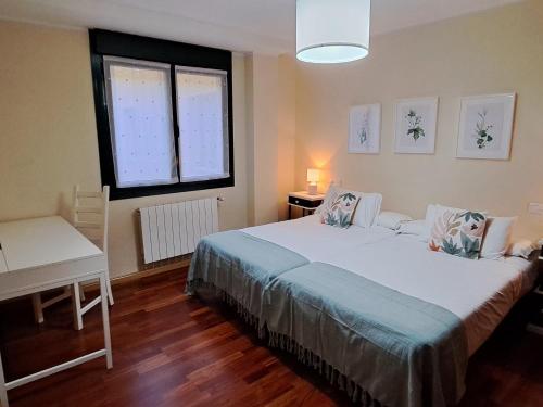 Un dormitorio con una cama grande y una ventana en 24A01 Apartamento Cabrales, en Arenas de Cabrales
