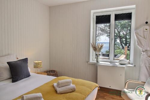 Schlafzimmer mit einem Bett und einem Fenster in der Unterkunft Villa caroline in Trébeurden