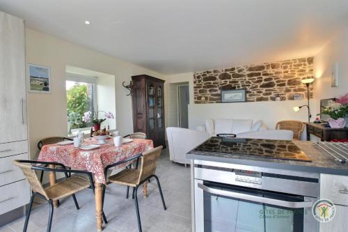 Il comprend une cuisine et un salon avec une table et une cuisinière. dans l'établissement Ipanema, à Trébeurden
