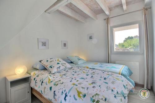 a bedroom with a bed and a window at Ipanema in Trébeurden
