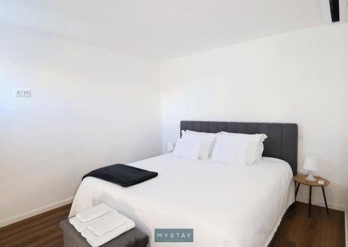 a bedroom with a large white bed with white pillows at MyStay - D Maria Apartments in Vila Nova de Famalicão