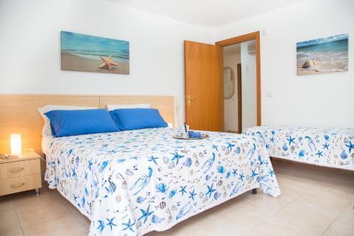 1 Schlafzimmer mit 2 Betten mit blauer und weißer Bettwäsche in der Unterkunft Villetta Concetta in Marina di Pescoluse