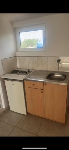 a small kitchen with a sink and a window at Babulje in Ulcinj