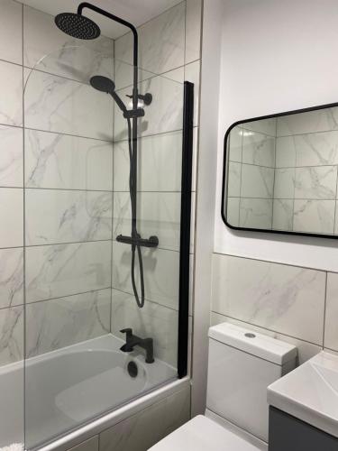 a bathroom with a shower and a tub and a toilet at Stylish Apartments near the sea front at Morecambe in Heysham