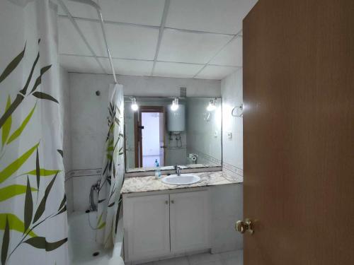 a bathroom with a sink and a mirror at A H Rentals Carles III Apartamento 150mtrs playa in Sant Carles de la Ràpita