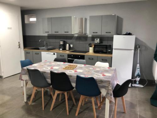 une cuisine avec une table avec des chaises et un réfrigérateur dans l'établissement appartement 8 couchages 201, à Laveissière