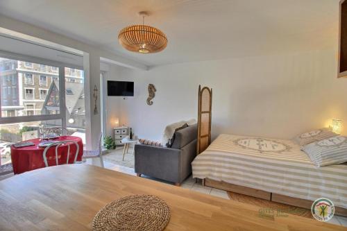 une chambre avec un lit et une grande fenêtre dans l'établissement Studio du phare, à Perros-Guirec