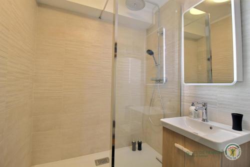 une salle de bain avec douche et lavabo dans l'établissement Studio du phare, à Perros-Guirec