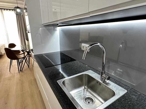un bancone della cucina con lavandino e piano cottura di A H Rentals Picasso apartamento a Vinarós