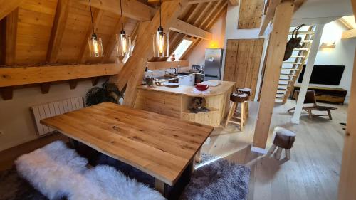 een kamer met een houten tafel aan het plafond bij Les Suites du Monetier, alliant le charme et l'authenticité d'un chalet de prestige au cœur du village in Le Monêtier-les-Bains
