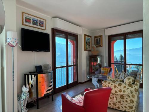a living room with a tv and a couch and chairs at Lakeside Design Apartment Casa Manola - Larihome A44 in San Siro
