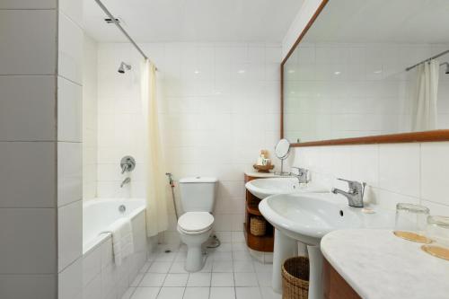 a white bathroom with a toilet and a sink at Inya Lake Hotel in Yangon