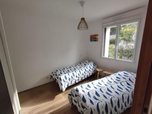 deux lits dans une chambre avec une fenêtre dans l'établissement Maison Le Phare, 4 personnes, à La Tranche-sur-Mer
