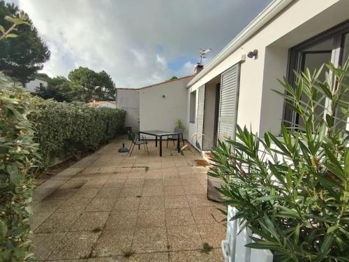 un patio avec une table et des chaises à côté d'un bâtiment dans l'établissement Maison Le Phare, 4 personnes, à La Tranche-sur-Mer