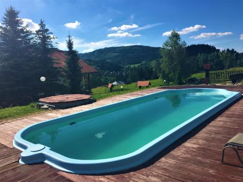une grande piscine sur une terrasse en bois dans l'établissement Willa Podgórska, à Korbielów
