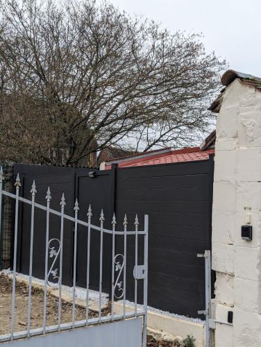 a black fence with two skulls painted on it at Le Studio du Marais in Aux Marais