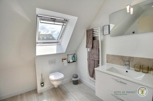 ein Bad mit einem Waschbecken, einem WC und einem Fenster in der Unterkunft Ker'luane in Lézardrieux