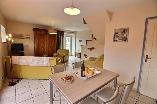 une cuisine et un salon avec une table et des chaises dans l'établissement Le four a pain, à Pleubian