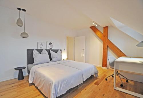 Schlafzimmer mit einem weißen Bett und Holzboden in der Unterkunft Design-Highlight: Stilvolles Altstadt-Apartment! in Wittlich