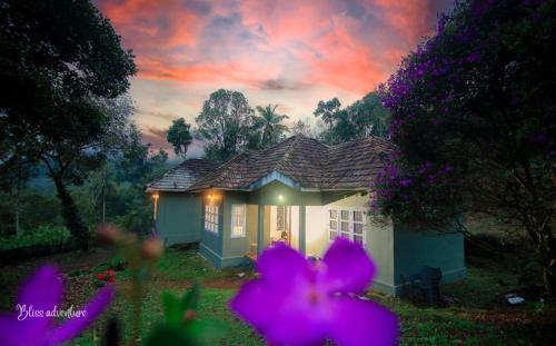 uma pequena casa com flores roxas em frente em Breeze Hill resort em Viripara