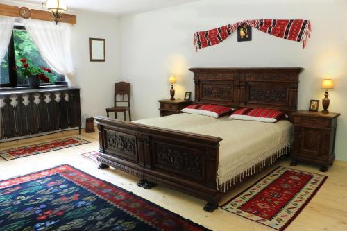 a bedroom with a wooden bed with red pillows on it at Cabana Izvoranu in Izvoranu