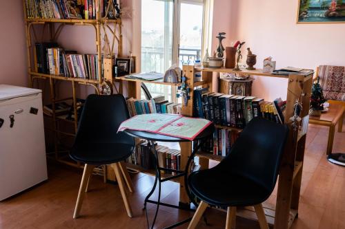 um quarto com duas cadeiras e uma estante de livros com livros em Fani's Family House em Ierápetra