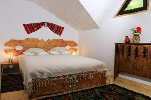 a bedroom with a large bed with a wooden headboard at Cabana Izvoranu in Izvoranu