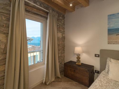 a bedroom with a bed and a large window at B&B Vistalago in Toscolano Maderno