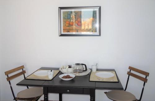 a table with two chairs and a picture on the wall at Panoramic View apartment in Poros