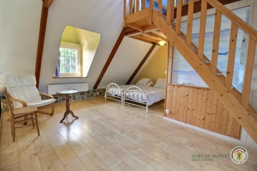a living room with a staircase and a bed at Anermitte in Plouguiel