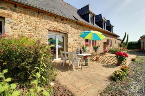 a patio with a table and an umbrella at Anermitte in Plouguiel