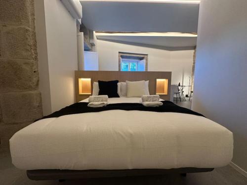 a bedroom with a large white bed with two pillows at Luxury Downtown C. Del Tratado B in Vigo