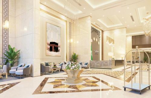 een lobby van een hotel met een vaas met bloemen bij TIME Ruba Hotel & Suites in Mekka