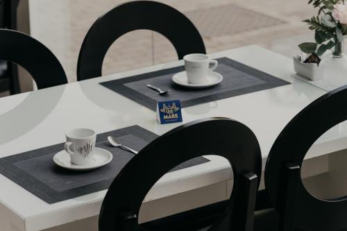 a white table with two cups and saucers on it at Mare Hotel in Dos Hermanas