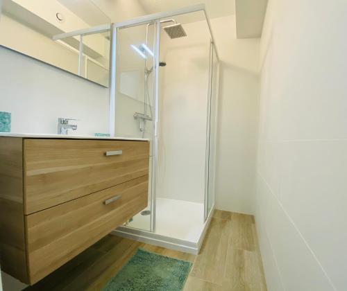 La salle de bains est pourvue d'une douche et d'une commode en bois. dans l'établissement Appartement 8 Les Carolines 2 Calvi, à Calvi