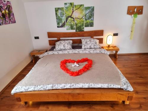 Dormitorio con cama con almohada de corazón en Vineyard cottage Matej, en Trebnje