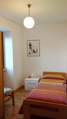 een slaapkamer met een bed, een tafel en een lamp bij Al Piccolo Borgo Antico in Torri del Benaco