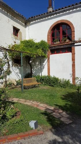 a bench in front of a building with a window at Belle Lauragaise ensoleillée in Issel