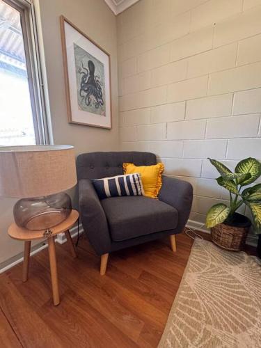sala de estar con silla azul y mesa en Roomy Seaside Apartment, en Port Hedland