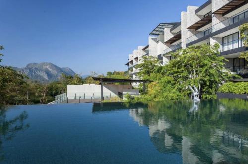 una grande piscina d'acqua di fronte a un edificio di Botanica Khaoyai (Suite, 64 sqm) Mountain View a Mu Si