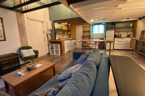 un salon avec un canapé bleu et une cuisine dans l'établissement Vaste T2 Duplex Lille Beaux Arts - Renaud, à Lille