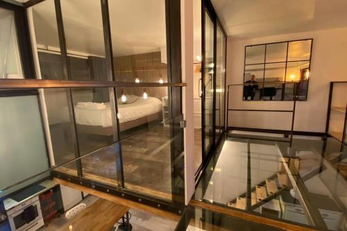 Cette chambre dispose de murs en verre et d'un lit. dans l'établissement Vaste T2 Duplex Lille Beaux Arts - Renaud, à Lille