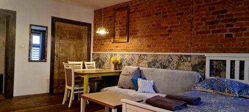 a living room with a couch and a brick wall at Staszica Starówka in Olsztyn