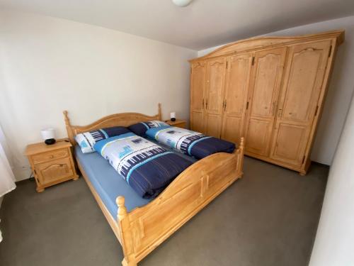 a bedroom with a wooden bed and a wooden cabinet at Disentis-Ferien in Disentis