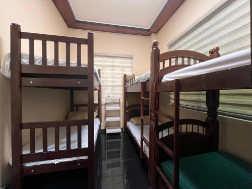 Zimmer mit 3 Etagenbetten und einem Fenster in der Unterkunft Furutech Resort in Malolos