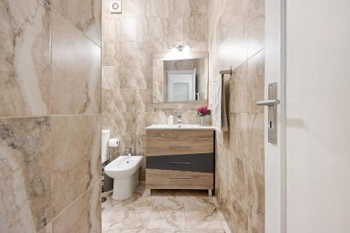 a bathroom with a sink and a toilet and a mirror at Trindade Porto City Centre in Porto